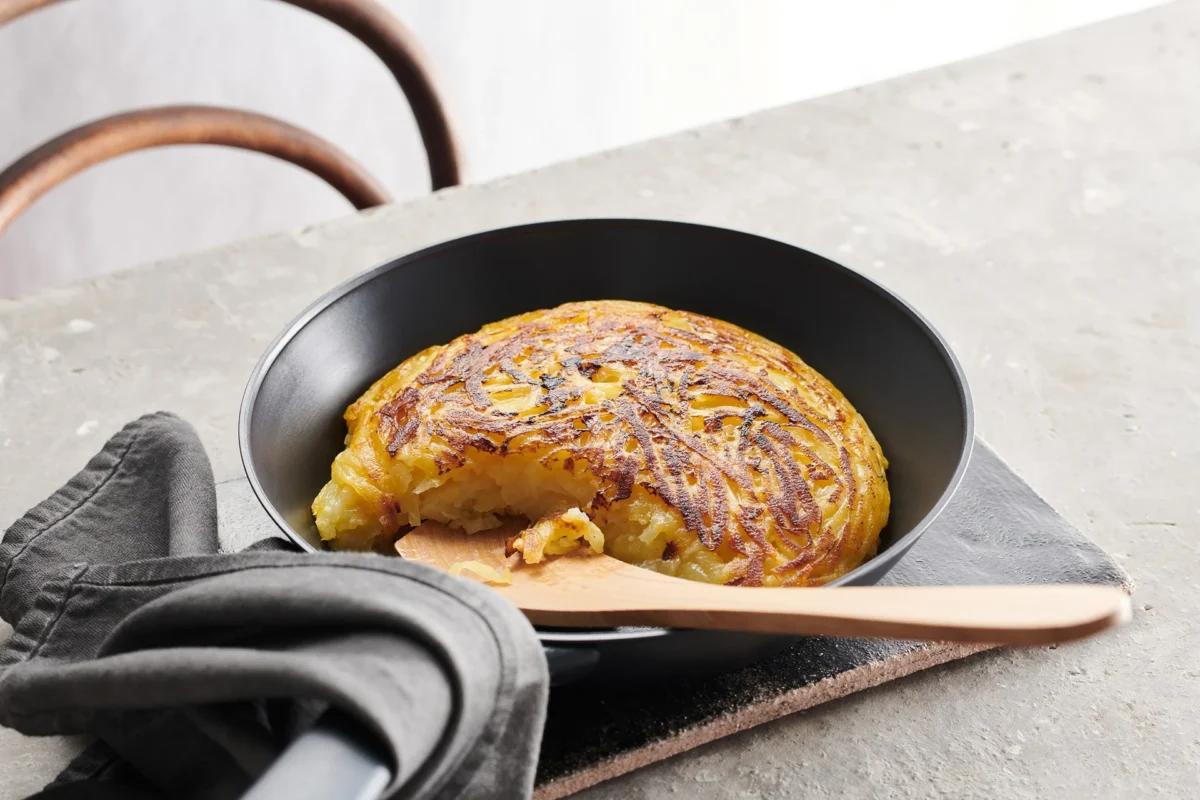 Rösti di patate crude aus der Kategorie Kartoffeln &amp; Süsskartoffeln. Das fertige Gericht schön angerichtet und fotografiert aus Vogelperspektive (Food Fotografie). Serviervorschlag, Original Tiptopf Rezept, aus dem bekanntesten Kochbuch der Schweiz