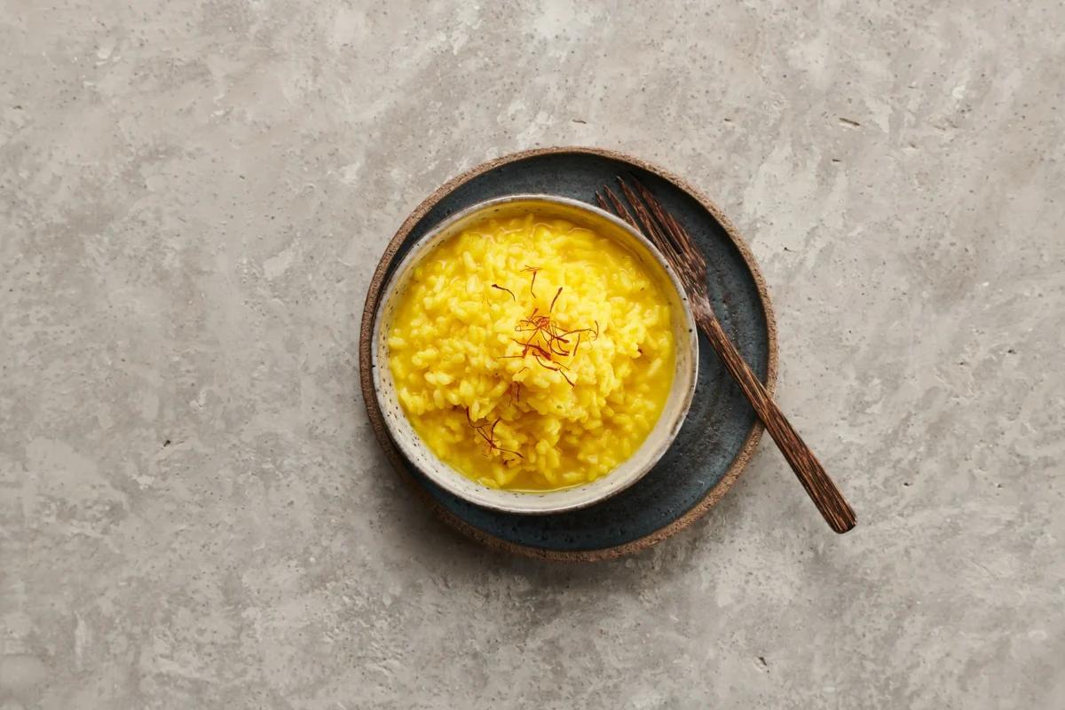 Risotto alla milanese. Das fertige Gericht schön angerichtet und fotografiert aus Vogelperspektive (Food Fotografie). Serviervorschlag, Original Tiptopf Rezept, aus dem bekanntesten Kochbuch der Schweiz