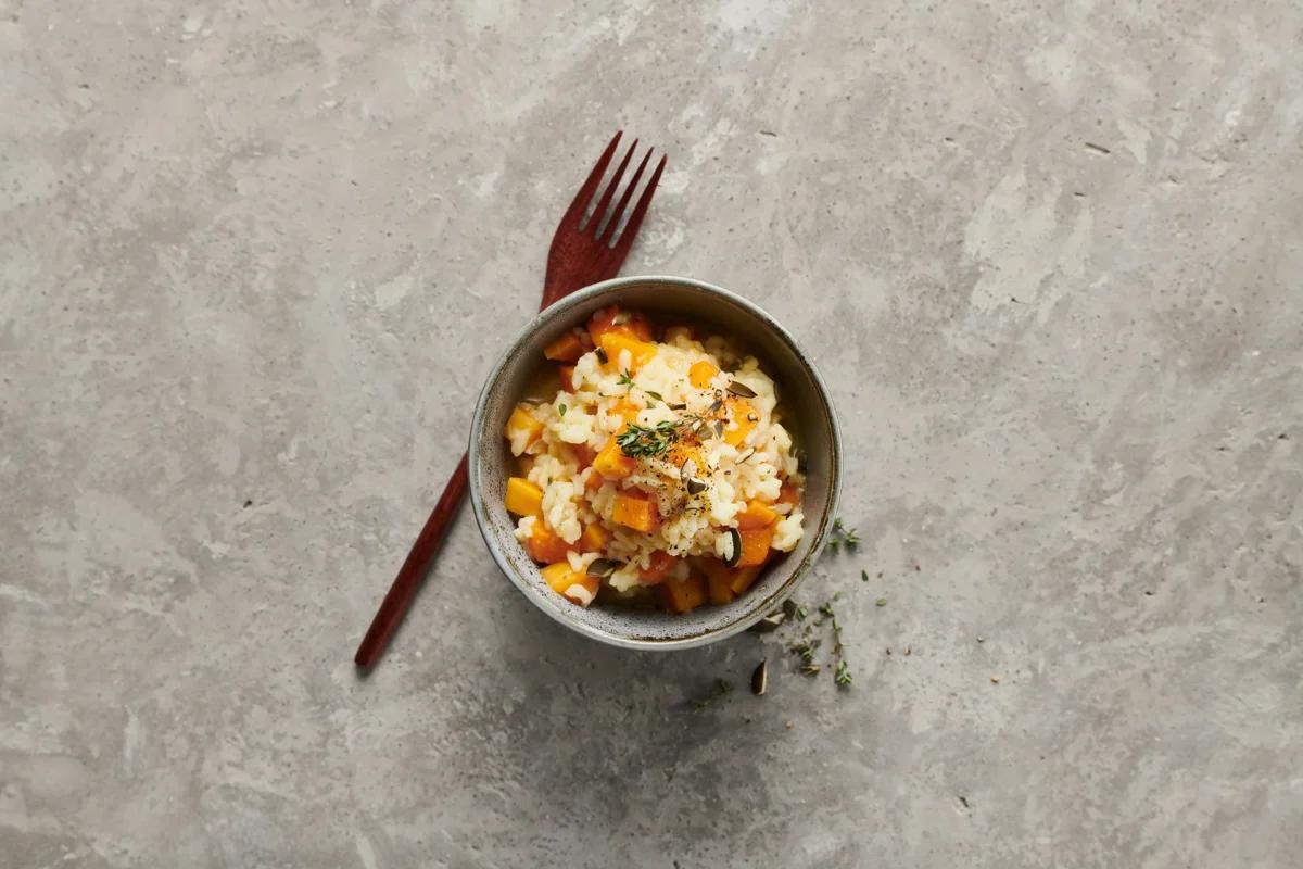 Risotto alla zucca aus der Kategorie Getreide. Das fertige Gericht schön angerichtet und fotografiert aus Vogelperspektive (Food Fotografie). Serviervorschlag, Original Tiptopf Rezept, aus dem bekanntesten Kochbuch der Schweiz