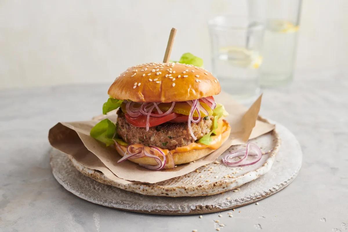 Hamburger aus der Kategorie Fleisch & Fisch. Das fertige Gericht schön angerichtet und fotografiert aus Vogelperspektive (Food Fotografie). Serviervorschlag, Original Tiptopf Rezept, aus dem bekanntesten Kochbuch der Schweiz